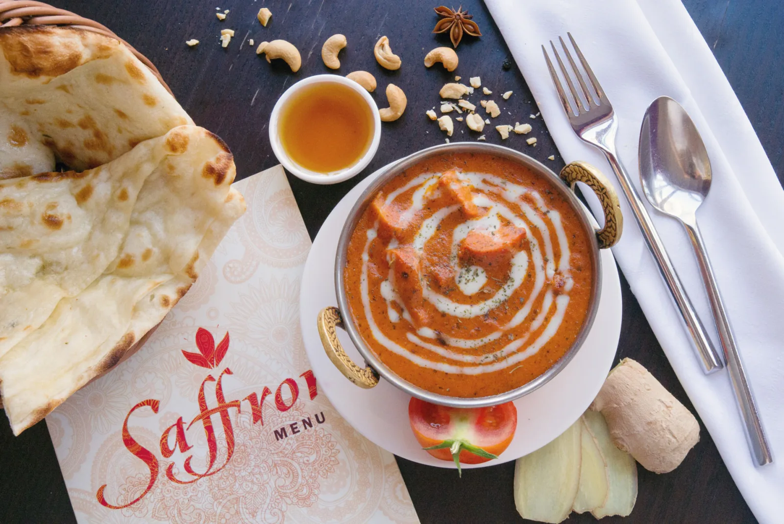 Butter chicken in Saffron’s handled serving bowl, photographed on the table with naan